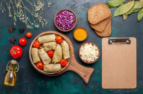 top view tasty meat meal rolled with cabbage and tomatoes called dolma with bread and olive oil on dark-blue desk meat food dinner vegetable dish cooking